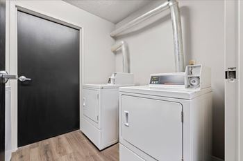 A room with a black door and two white appliances.